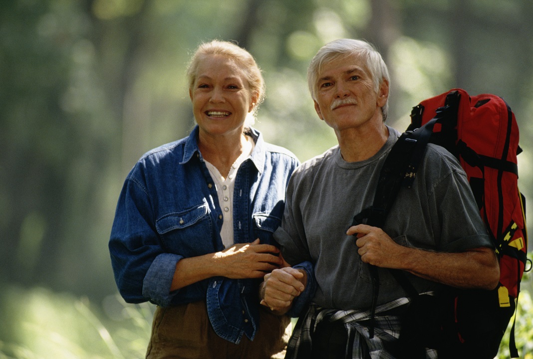 Elderly couple hiking in the woods in one of the best places to retire on the West Coast.
